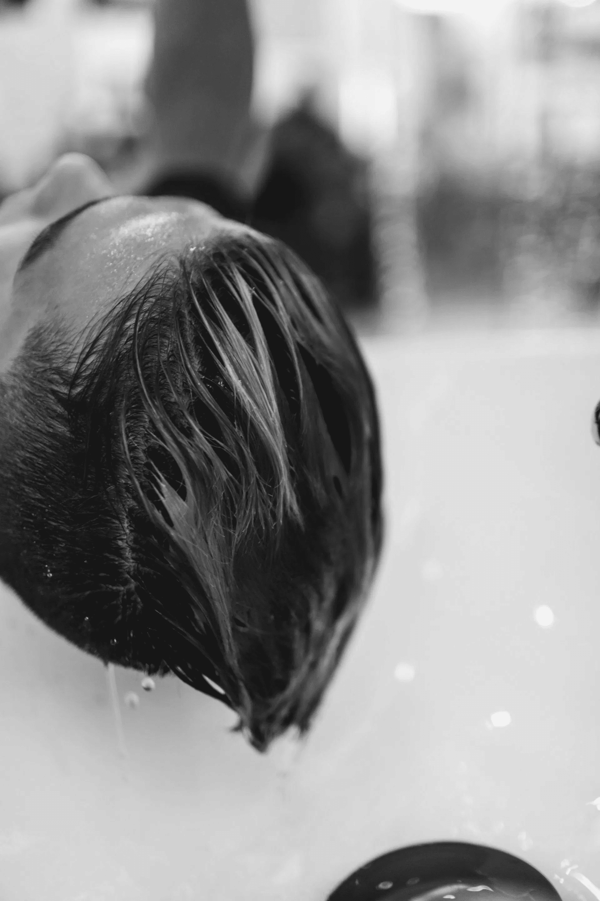Man getting hair washed at a salon sink.