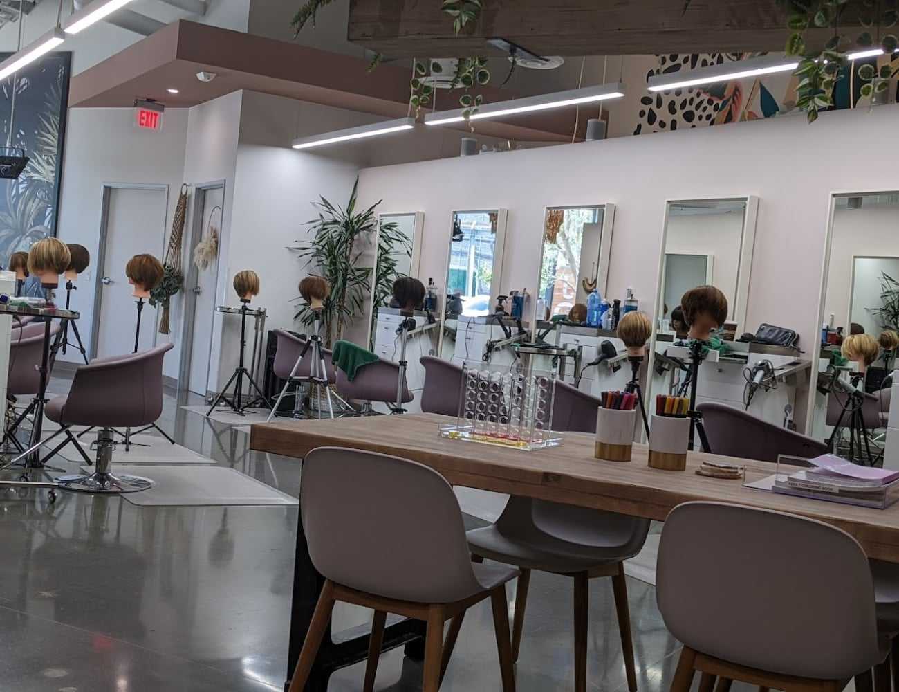 Modern hair salon with styling stations and mannequin heads for practice.